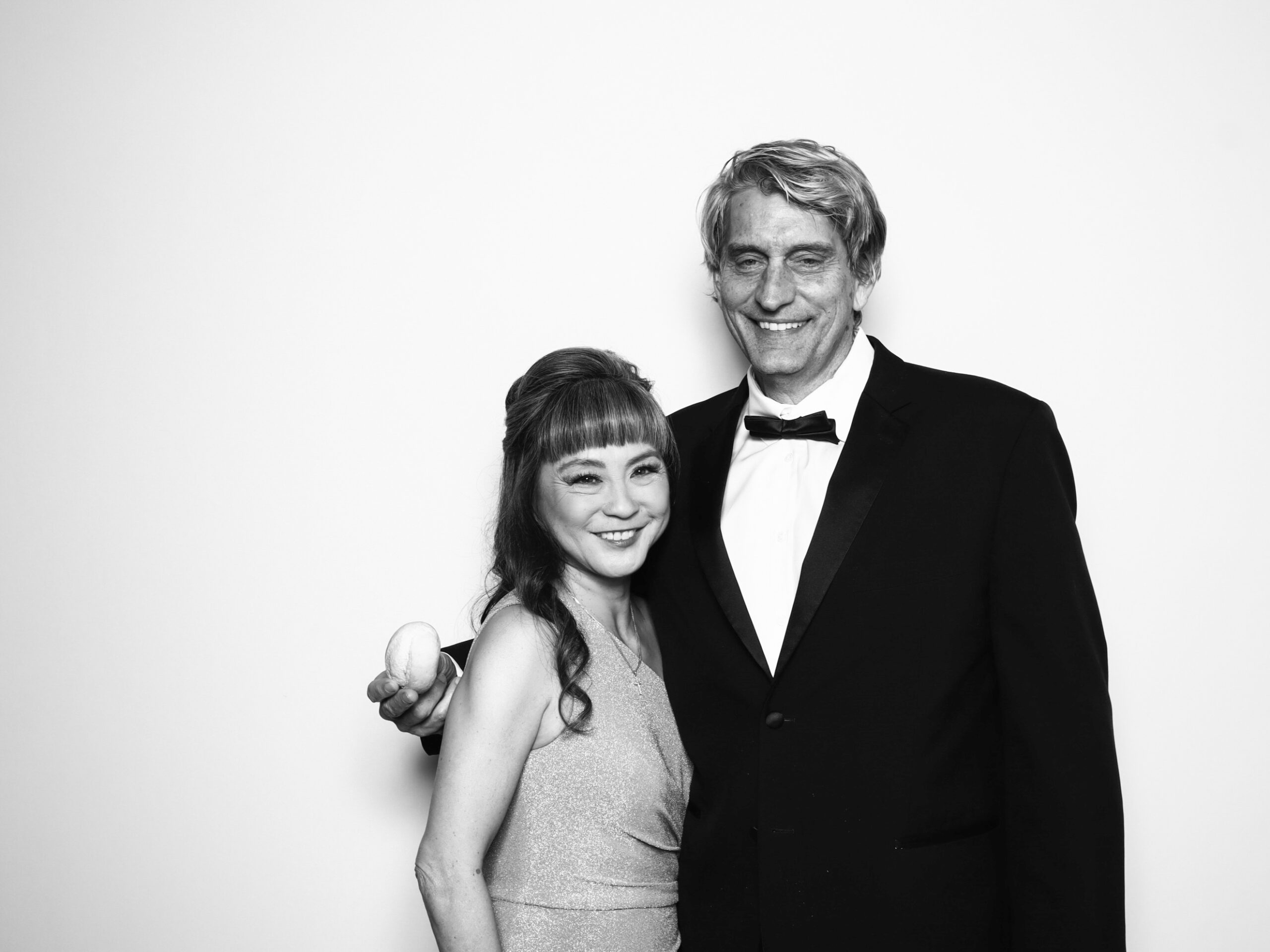 Guest inside a glowing 360 photo booth enclosure at a luxury Orlando event