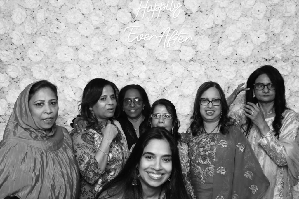Family posing together with props at a quinceañera photo booth

