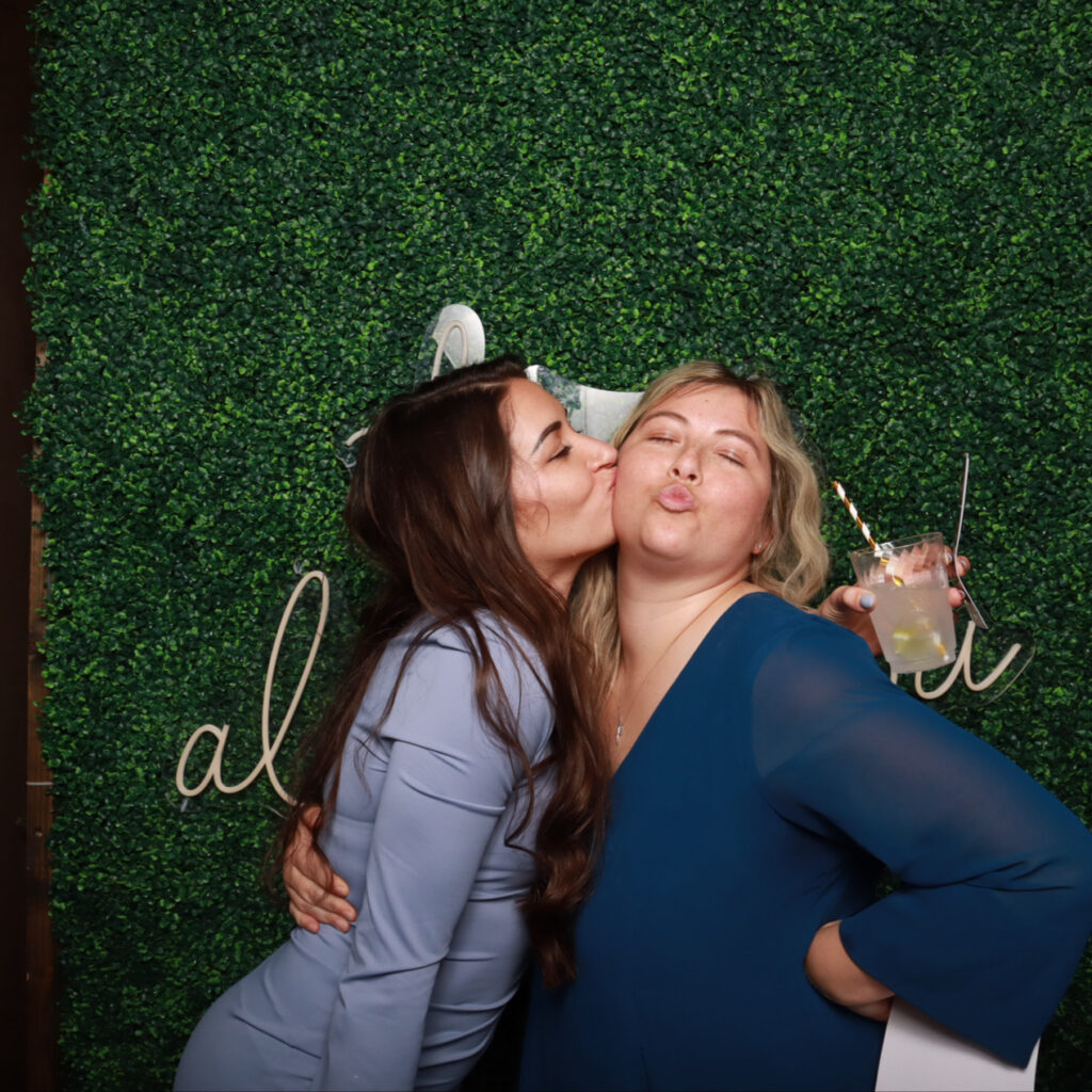 Guests using a photo booth next to lounge area at Port Orange celebration

