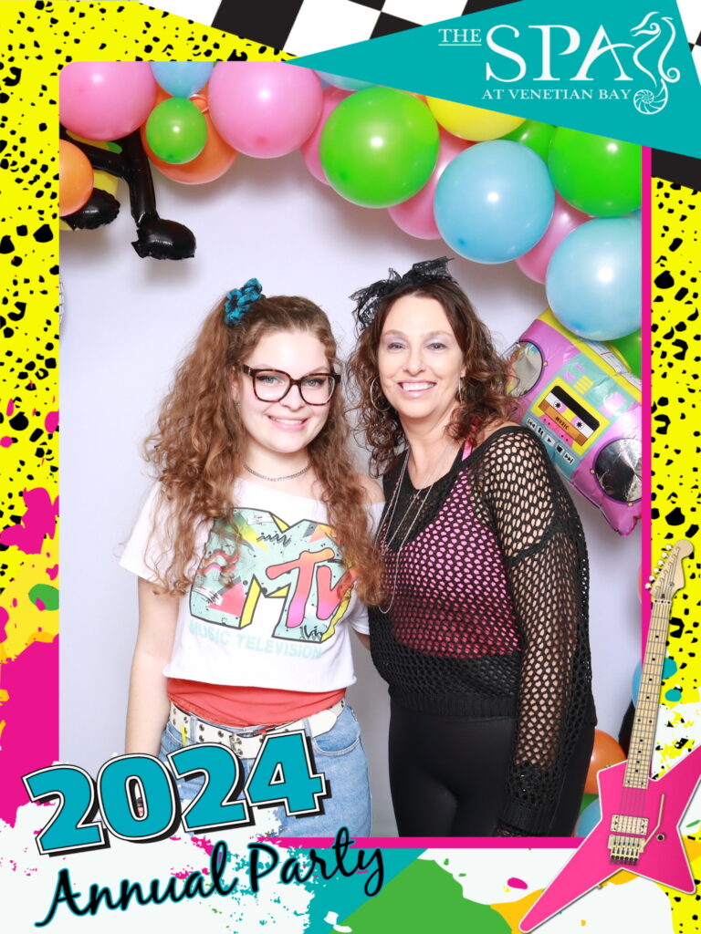 Friends in retro costumes posing with balloon backdrop at The Spa at Venetian Bay’s 2024 Annual 80’s Party.