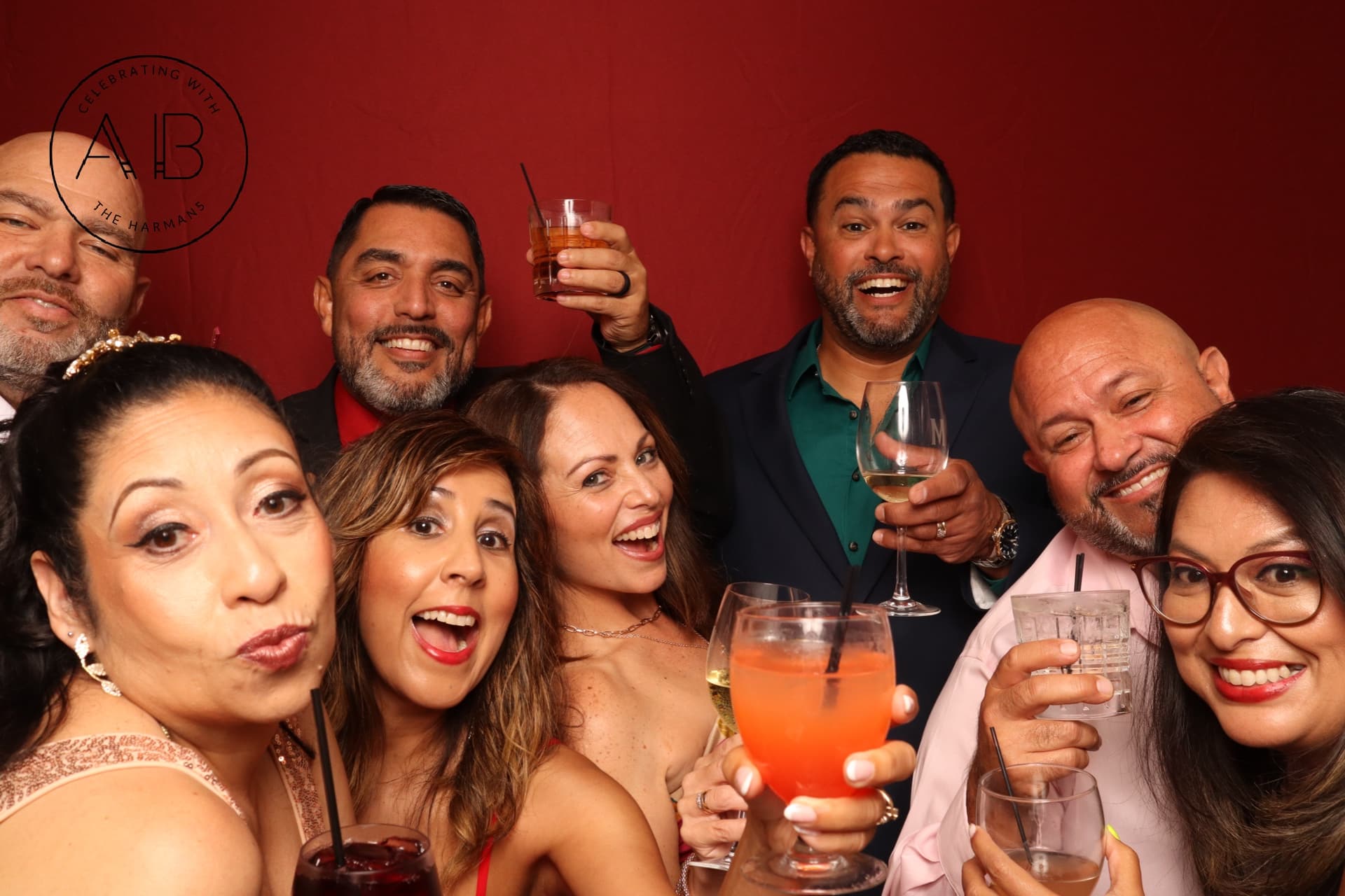 Guests laughing and holding drinks in a red photo booth backdrop at Lake Mary wedding – Lake Mary photo booth rental by Strata Booth